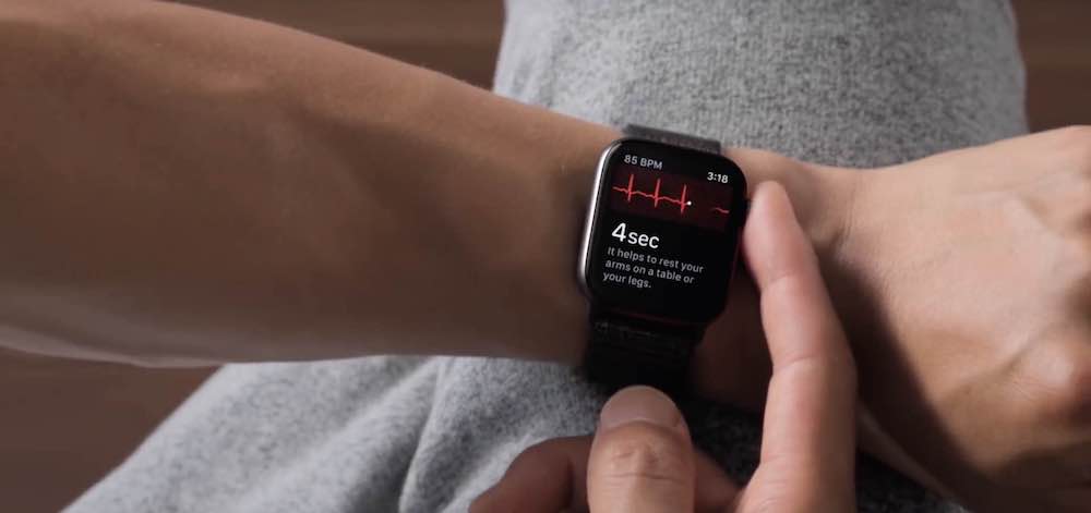 A person recording an Apple Watch ECG with both arms rested and relaxed, the watch arm supported